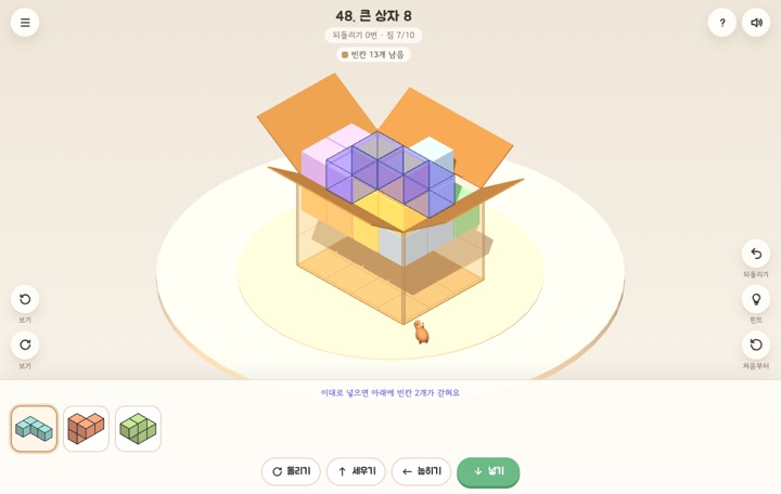 반쯤 채운 이삿짐 상자 위로 넣을 자리를 보라색 블록으로 미리 보여주는 3D 화면